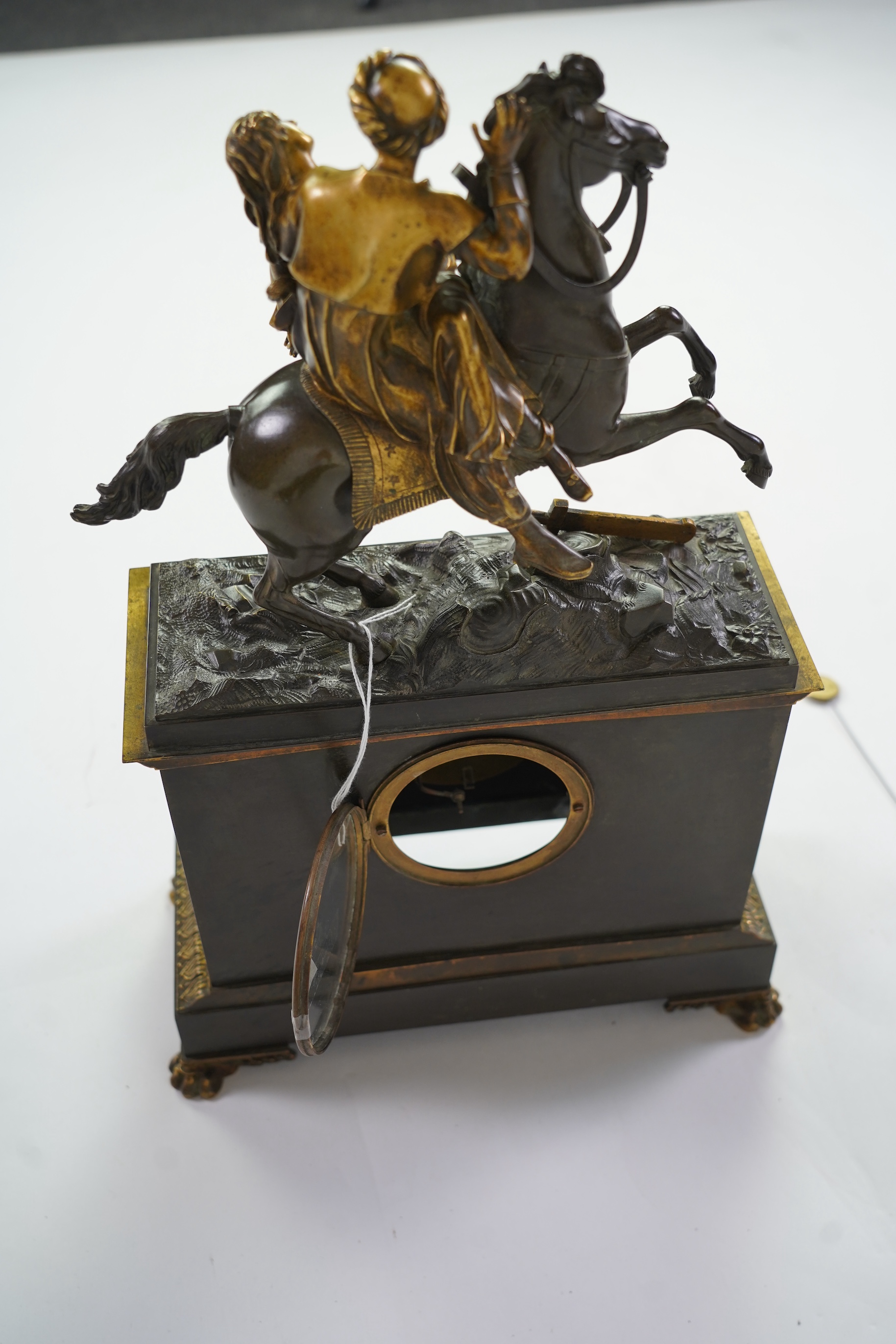 A late nineteenth century brass and bronze cased clock, mounted with a part gilt bronze of a mounted Turkish soldier and woman